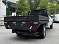 A 2020 Ford F-350 SD with a flatbed featuring metal grating and multiple rear lights parked with a focus on its back end and tow hitch