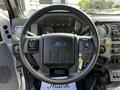 A steering wheel of a 2016 Ford F-550 featuring controls and the Ford logo in the center