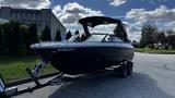 A 2023 Mercury Monterey boat on a trailer with a sleek black design and a raised canopy