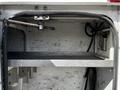 An open compartment of a 2008 Ford F-550 with a metal shelf visible inside and a cable mechanism along the top edge