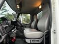 Interior view of a 2018 Freightliner M2 106 showing two gray leather seats and a dashboard with various controls and displays