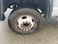 A close-up of a tire on a 2008 Dodge Ram 5500 showing tread wear and a rusty wheel rim