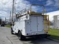 A 2008 Ford F-550 truck with a utility service body and aerial lift equipment mounted on the back, featuring a yellow ladder and tool compartments