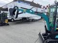 A 2024 AGT Industrial Green QH13R Mini Excavator with a distinctive boom arm and bucket attachment in focus