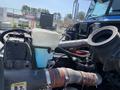 A close-up view of the engine components of a 2008 Peterbilt 340 with visible hoses coolant reservoir and turbocharger piping