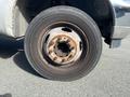 Close-up of a rusty wheel rim mounted on a tire from a 2003 Ford F-450 SD showing visible wear and tear