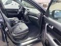 Interior view of a 2015 Kia Sorento featuring black leather seats a center console and dashboard with controls and displays