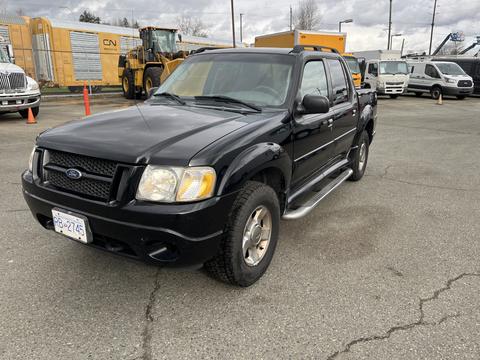 A black 2004 Ford Explorer Sport Trac parked with side steps and a front grille featuring the Ford emblem