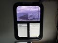 The image shows a 2006 GMC C5000 truck parked outside a window with a view of the truck's cab and cargo area visible through the glass