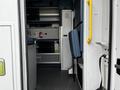 Interior view of a 2013 Chevrolet Express featuring seating and storage compartments with a unique layout