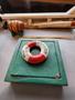 A green wooden box with a red and white life preserver on top labeled Onwego and a small wooden barrel beside it