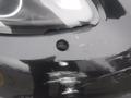 Close-up of a black 2016 Porsche Boxster front light showing a small hole and scratches on the surface