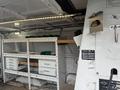 A 2008 Ford Econoline van with interior shelves and storage drawers organized for tools and equipment