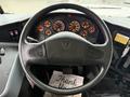 The interior view of a 2016 International CE300 bus showing the steering wheel with various gauges and controls including speedometer and warning lights