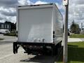 A white 2016 Isuzu NQR box truck parked on a street with a simple rear view showing no visible markings or logos