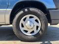 A close-up of a silver alloy wheel and tire from a 2008 Ford E-350 showing the Ford emblem on the wheel hub