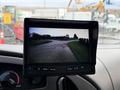 A rearview camera display showing a view of a road with a traffic cone ahead in a 2007 Ford E-350 van