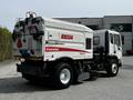 2012 Autocar Xpert street sweeper with a rear-mounted Elgin Crosswind sweep mechanism and various safety labels