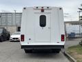 A white 2014 Ford E-350 van viewed from the rear with a single door and no visible windows