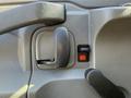 Close-up of the interior door handle and window controls of a 2021 Chevrolet Express with textured gray surfaces and a red button