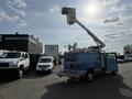 A blue 2010 Ford Econoline van with a raised aerial lift on its roof and open side doors showcasing interior modifications