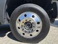 Close-up of a chrome wheel rim and tire from a 2016 Ford F-550 showcasing the five lug nuts and detailed tire tread design