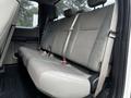 The interior of a 2017 Ford F-250 showing the rear bench seat with gray cloth upholstery and seatbelts
