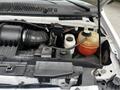 Engine compartment of a 2008 Ford Econoline showcasing various components including the air intake and coolant reservoir