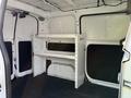 Interior of a 2021 Nissan NV200 van featuring a white shelving unit installed on the left side of the cargo space