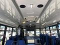 Interior view of a 2020 Chevrolet Express showcasing seating rows with blue fabric and overhead lights