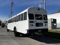 A 2022 Blue Bird Vision school bus in white with a distinctive design and multiple windows on the side