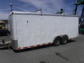 A white 2010 Forest River enclosed trailer with a flat roof and dual axles visible from the side