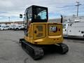 A yellow 2024 Caterpillar 306 mini excavator with a glass cab and tracks visible in the foreground
