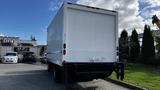 A white 2016 Isuzu NPR box truck with a rear loading door and no visible markings on the side