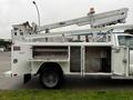 A 2004 Ford F-450 SD truck with a white exterior and an attached Altec aerial lift system mounted on the bed