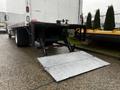 A rear view of a 2020 Hino 338 truck featuring a large hydraulic lift gate extended to the ground