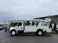 2007 International 4200 bucket truck with an extended aerial work platform and storage compartments on the side