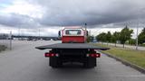 A 2015 International DuraStar 4300 truck with a flatbed facing the viewer showcasing its taillights and rear design