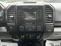 Dashboard of a 2016 Ford F-150 featuring a central touchscreen display surrounded by control buttons and dials for audio and climate settings