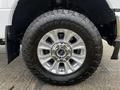 A close-up of a silver wheel from a 2020 Ford F-350 SD featuring a rugged tire with an aggressive tread pattern and a shiny aluminum rim design