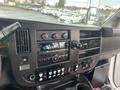 Dashboard of a 2018 Chevrolet Express featuring a radio display air conditioning controls and various buttons and knobs for vehicle functions