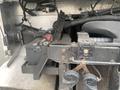 A 2012 Ford Econoline showing its engine compartment with battery and various components visible