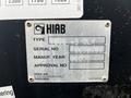 A metal identification plate labeled HIAB with type, serial number, manufacture year, approval number, and company information displayed on a black background