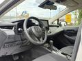 Interior view of a 2025 Toyota Corolla featuring a steering wheel a central display screen and modern dashboard controls