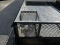 A 2008 Ford F-550 truck bed with a metal mesh enclosure and a rectangular opening in the center