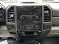 The interior dashboard of a 2017 Ford F-250 SD featuring the audio system control panel with buttons and knobs for temperature and settings