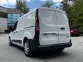 A 2014 Ford Transit Connect van in white parked with its rear view visible showing the tail lights and sliding door on the side