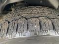 Close-up of the tread on a tire from a 2006 Land Rover LR3 showing rugged patterns and dirt on the surface