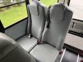 Two gray bus seats with seatbelts in a school bus interior