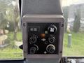 Control panel of a 2005 Case 570 featuring various buttons dials and switches for machine operation and climate control